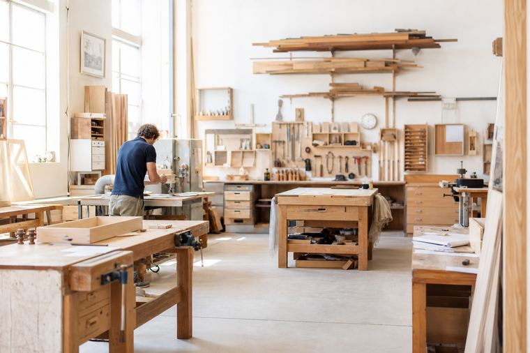 Mani sporche di argilla al lavoro sul tornio di una bottega di ceramica.