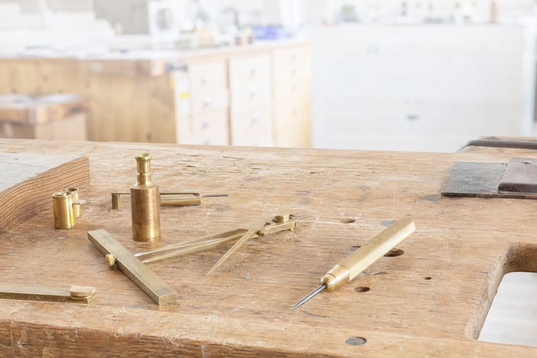 Uomo al lavoro vicino a una grande intelaiatura di legno grezzo appena montata.